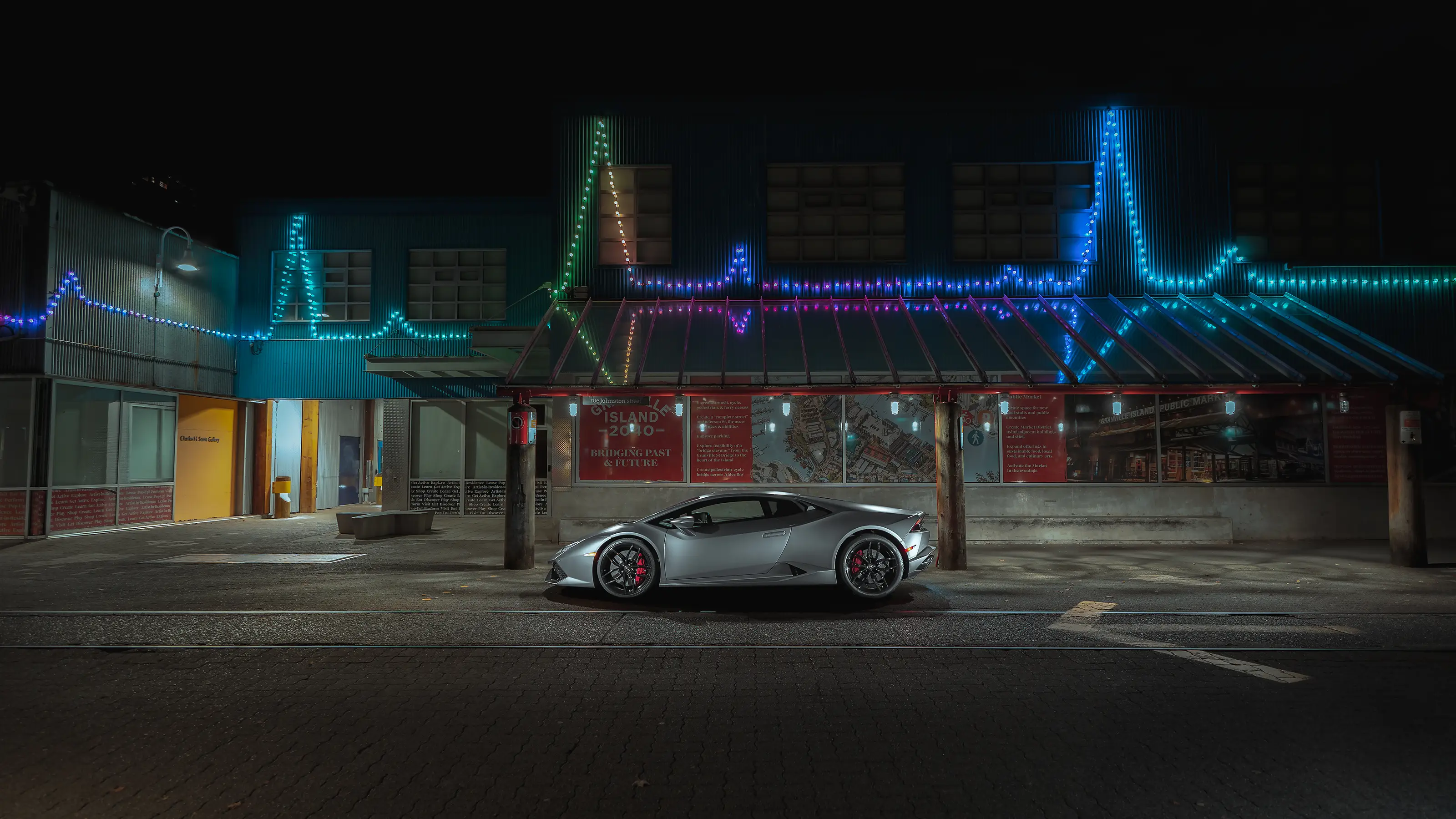 Side profile of the matte gray Huracán LP610 lit at night in Vancouver